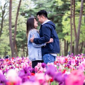 glückliches paar im blumenmeer am waldrand